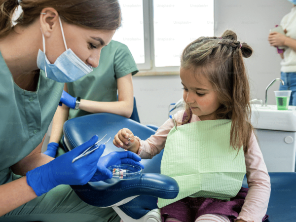 One of our dental professionals examining a young patient's teeth during a routine checkup