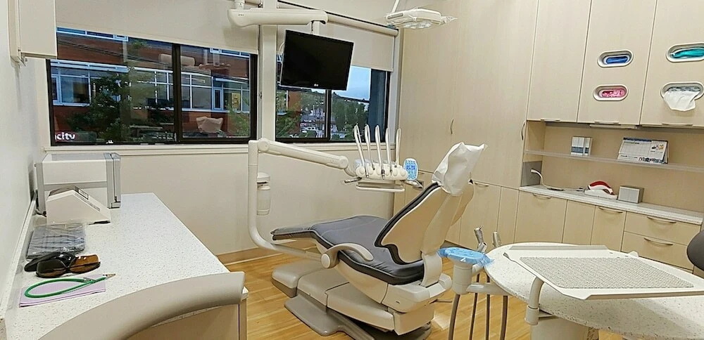 Modern dental office with a patient chair, equipment, and a window view. Ideal for finding a dentist near you.