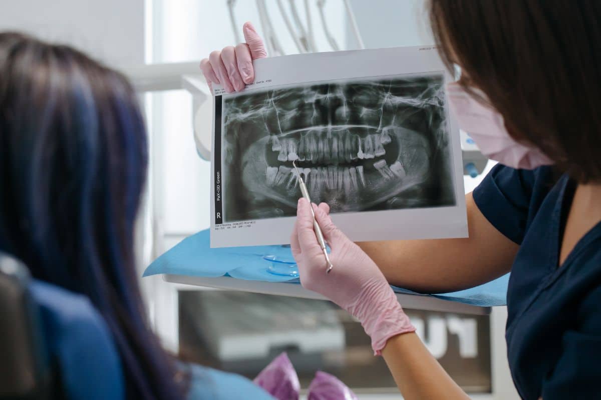 Dental professional reviewing panoramic X-ray with patient at our dental clinic