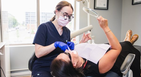 One of our dental professionals performing teeth cleaning on a patient in our dental clinic treatment room