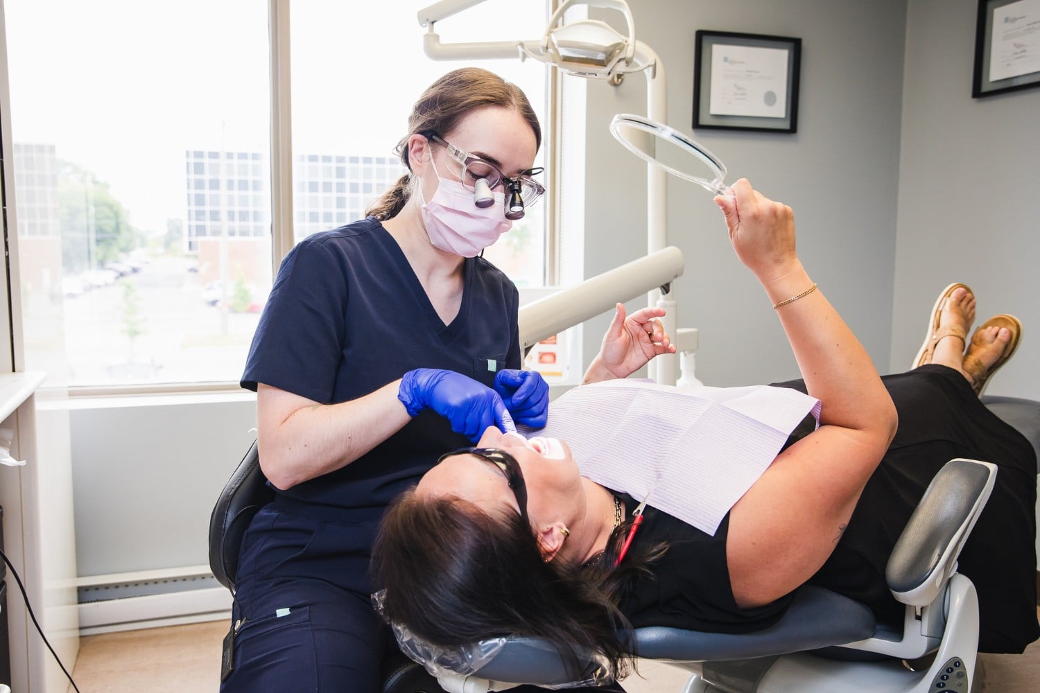 One of our dental professionals performing teeth cleaning on a patient in our dental clinic treatment room