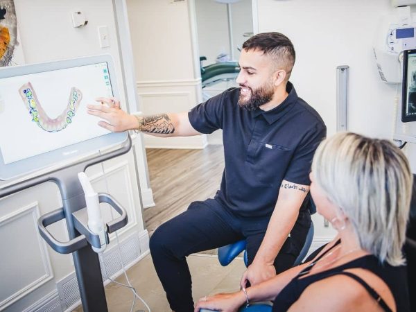 One of our dental professionals explaining treatment plan on touchscreen monitor to patient