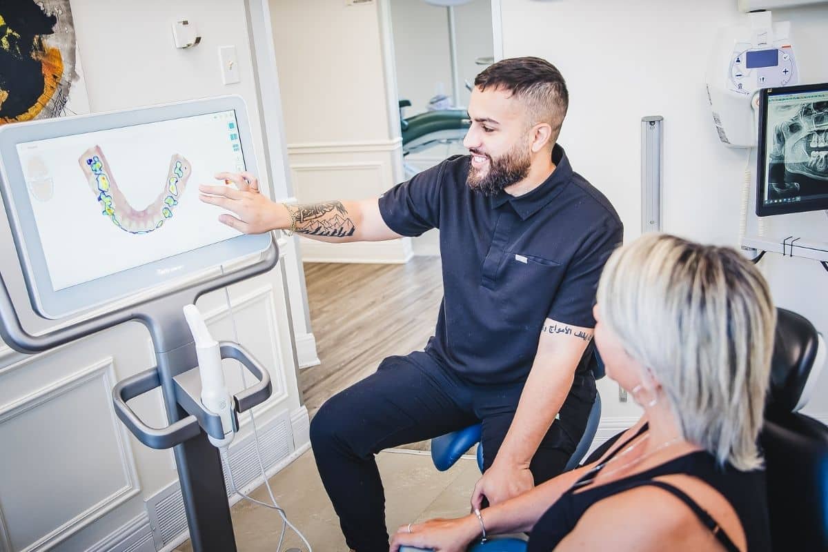 One of our dental professionals explaining treatment plan on touchscreen monitor to patient