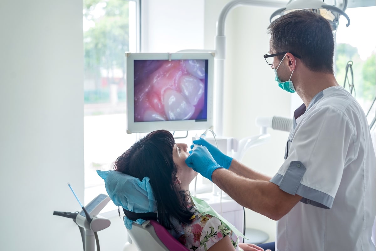 One of our dental professionals examining a patient's mouth with an intraoral camera during a dental procedure