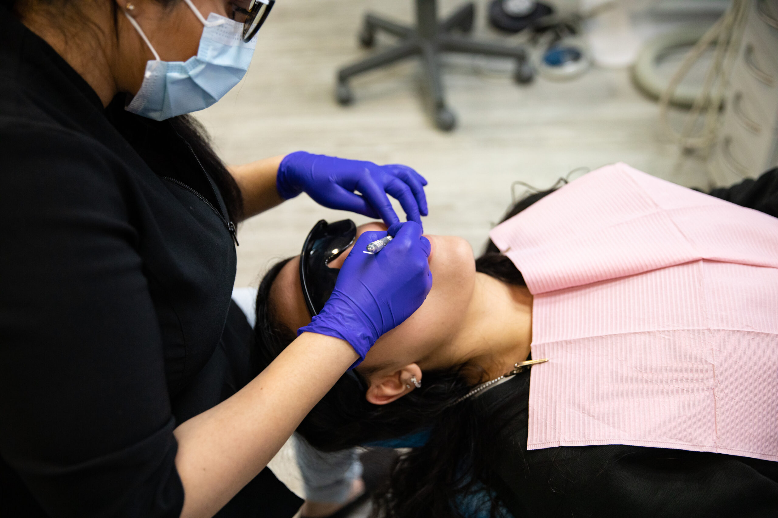 One of our dental professionals examining patient's teeth with intraoral camera