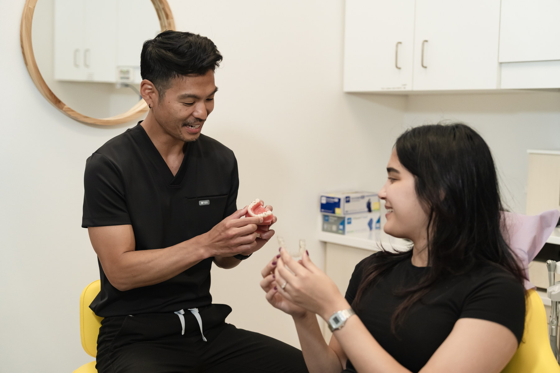One of our dental professionals showing a teeth model to a patient at our clinic