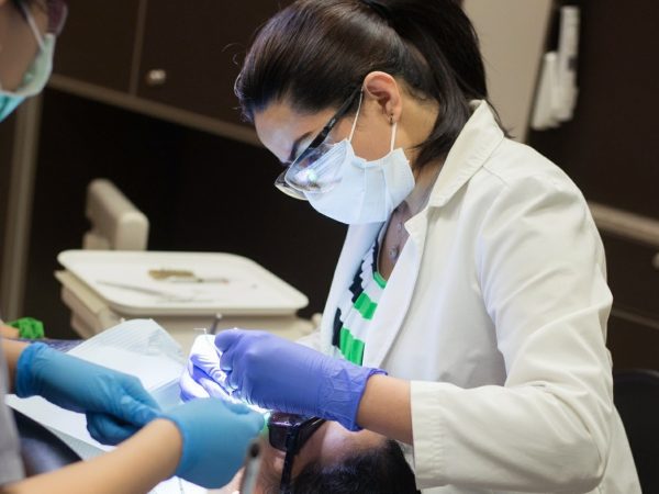 One of our dental professionals examining a patient's teeth with LED light during checkup