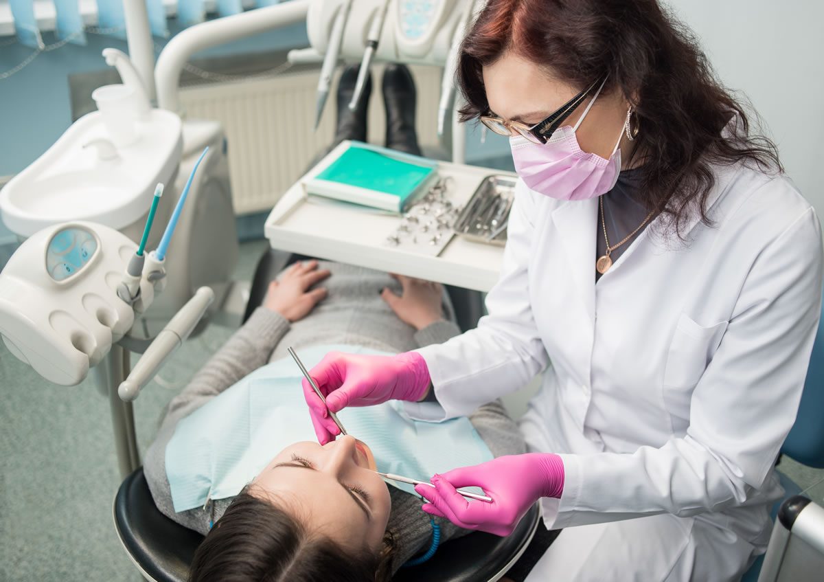 One of our dental professionals examining a patient's teeth during treatment