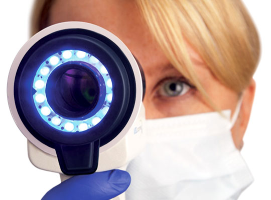 Dental professional using VELScope scanner for oral cancer screening
